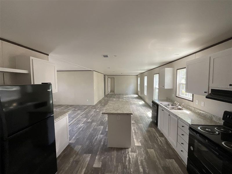 View from laundry room showing open kitchen, a peak at the living room and full view of family rom