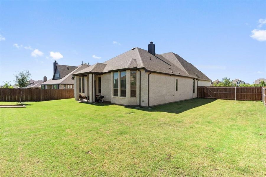 Rear view of house featuring a yard