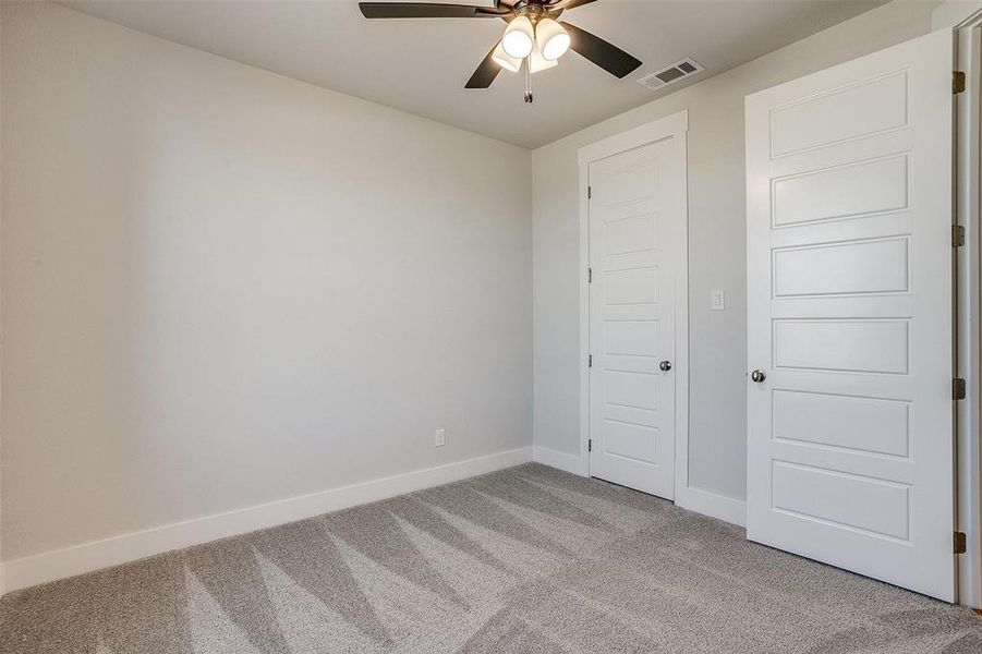 Unfurnished bedroom featuring a closet, ceiling fan, and light colored carpet