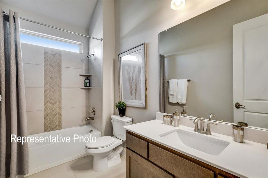 Full bathroom featuring tile patterned floors, vanity, toilet, and shower / tub combo with curtain