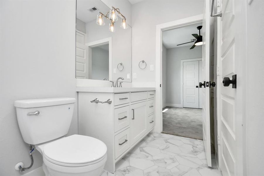 This view of the Hollywood bath highlights the lovely vanity area with ample cabinetry and shows the direct access to the secondary bedroom shown in the next photo!