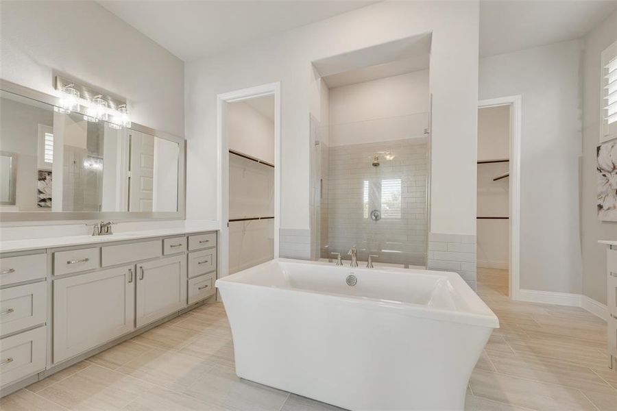 Bathroom with tile patterned floors, independent shower and bath, and vanity