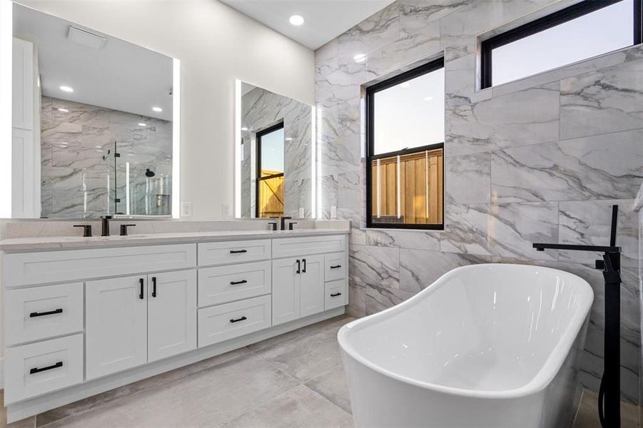 Bathroom with vanity, tile walls, and shower with separate bathtub