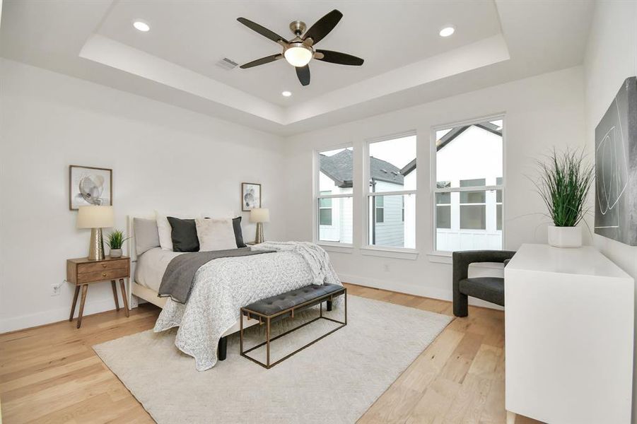 The primary bedroom comes fully equipped with tray ceilings and oversized windows.