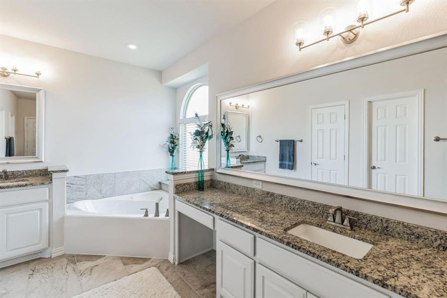 Bathroom with tile patterned flooring, a bath, and vanity