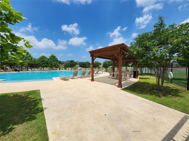 View of community pool featuring a lawn and a patio