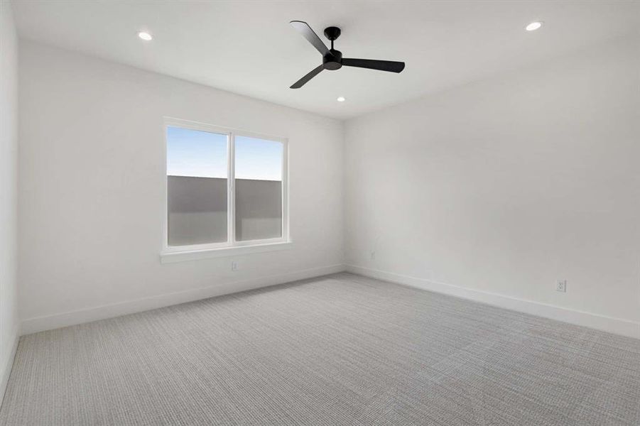 Carpeted empty room featuring ceiling fan