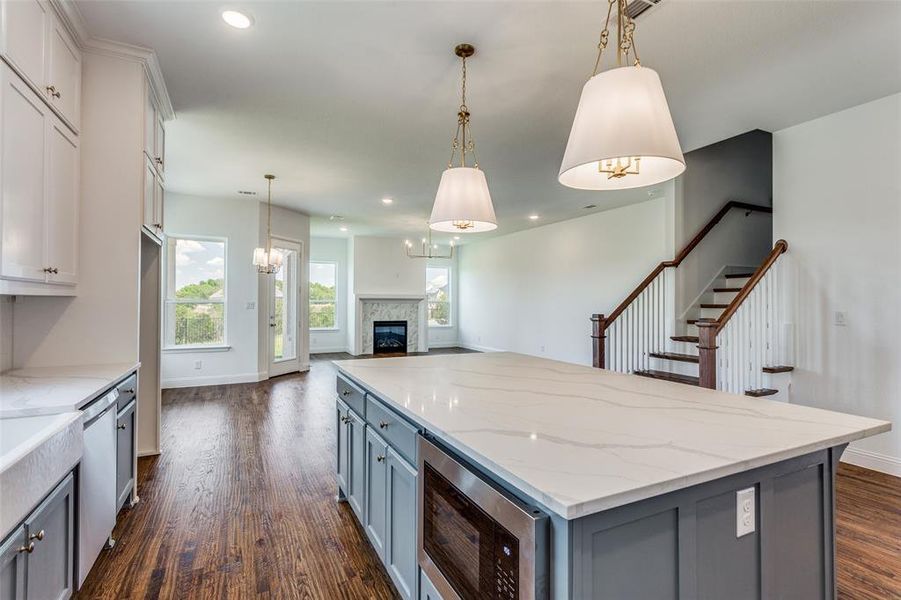 Kitchen featuring a center island, appliances with stainless steel finishes, dark hardwood / wood-style floors, and decorative light fixtures