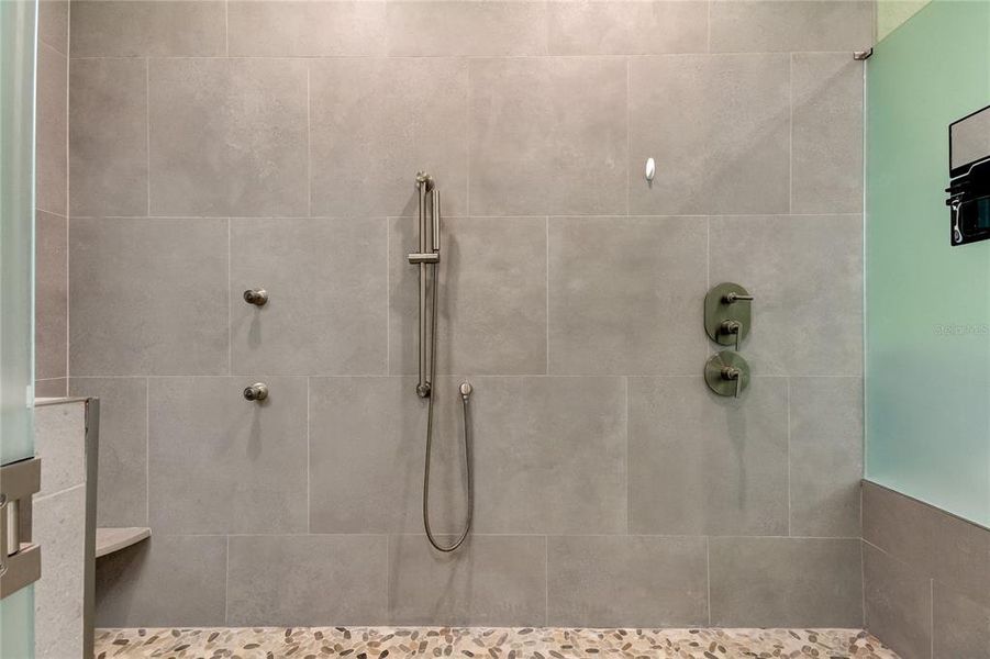 Primary bath zero entry shower with multiple shower heads.