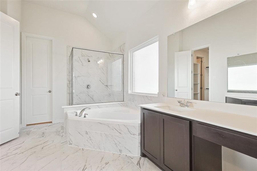 Bathroom with plus walk in shower, vanity, tile patterned floors, and lofted ceiling