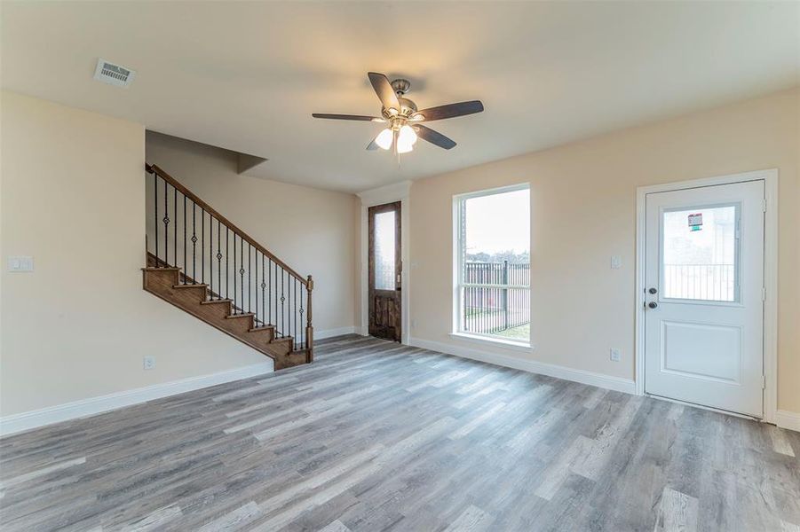 Unfurnished living room featuring light hardwood / wood-style flooring and ceiling fan