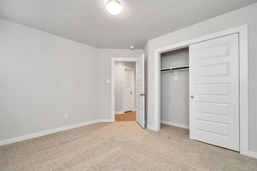 Generously sized secondary bedrooms featuring spacious closets, soft and inviting carpeting underfoot, large windows allowing plenty of natural light, and the added touch of privacy blinds for your personal retreat. Sample photo of completed home with similar floor plan. As-built interior colors and selections may vary.