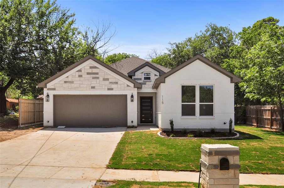 View of front of home featuring a garage and a front yard