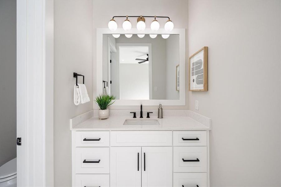 Bathroom with ceiling fan, toilet, and vanity