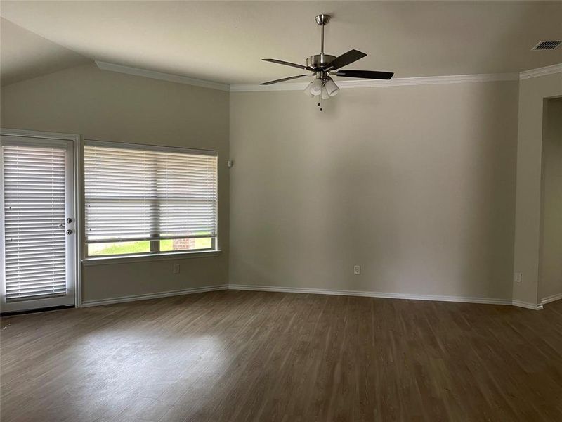 Empty room featuring lofted ceiling, ceiling fan, dark hardwood / wood-style floors, and ornamental molding