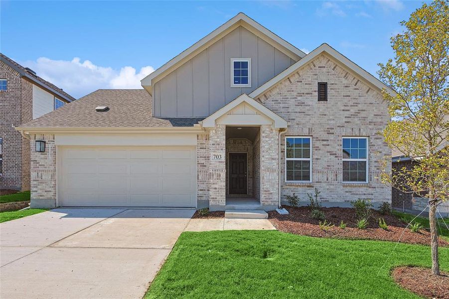 View of front of house with a garage and a front lawn