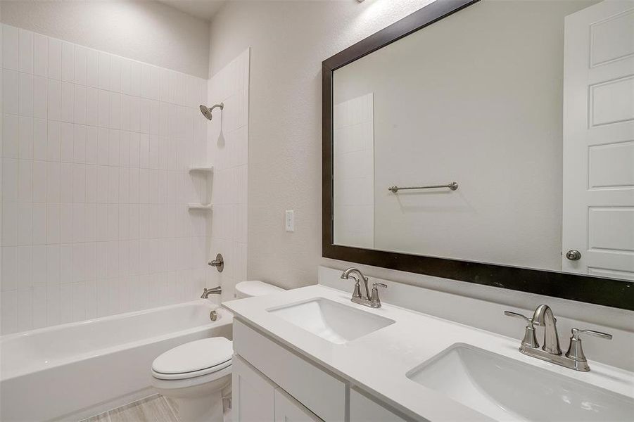 Full bathroom featuring vanity, toilet, and tiled shower / bath