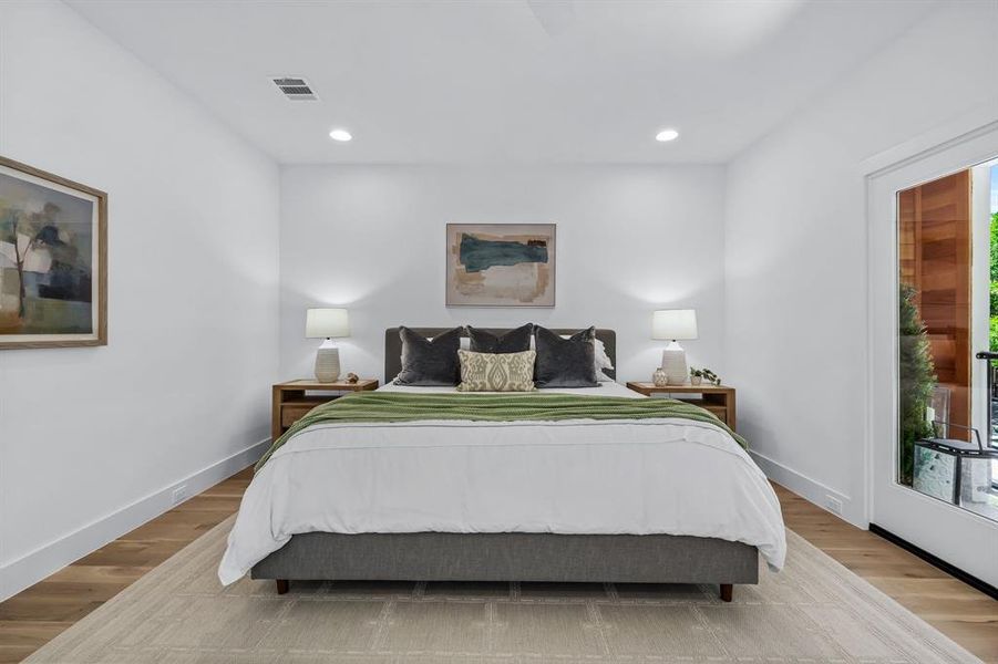 Bedroom with light hardwood / wood-style flooring and multiple windows