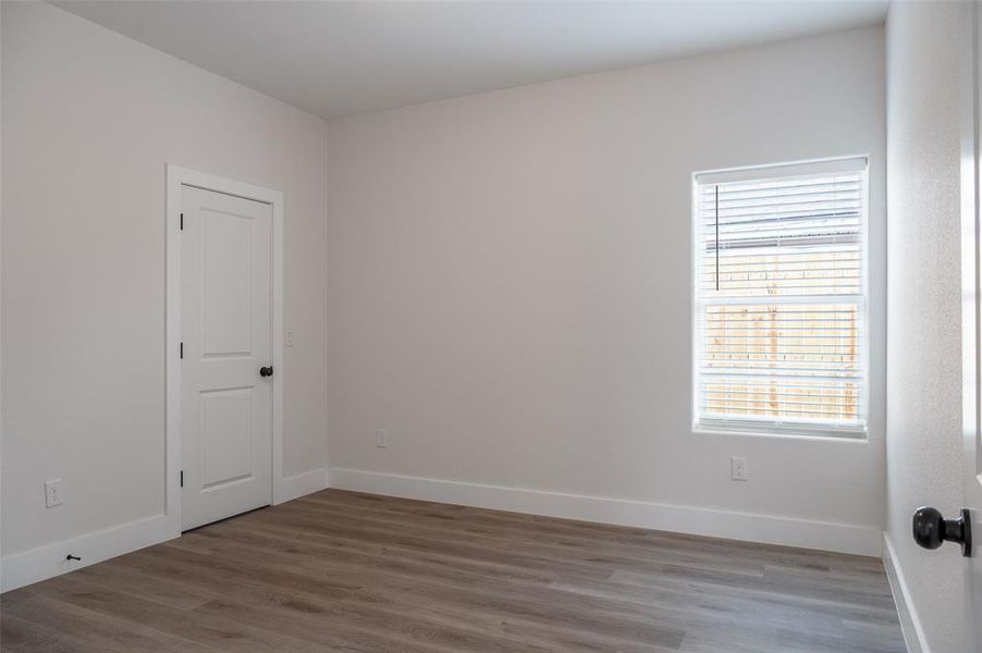 Unfurnished room with a healthy amount of sunlight and hardwood / wood-style floors