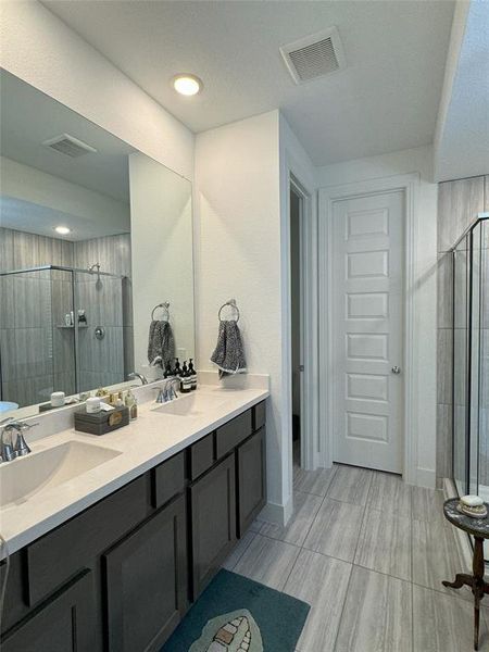 Bathroom with vanity, walk in shower, and toilet