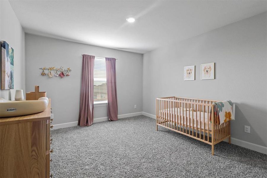 Bedroom with a nursery area and carpet