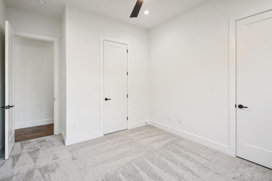 Unfurnished bedroom featuring light carpet and ceiling fan