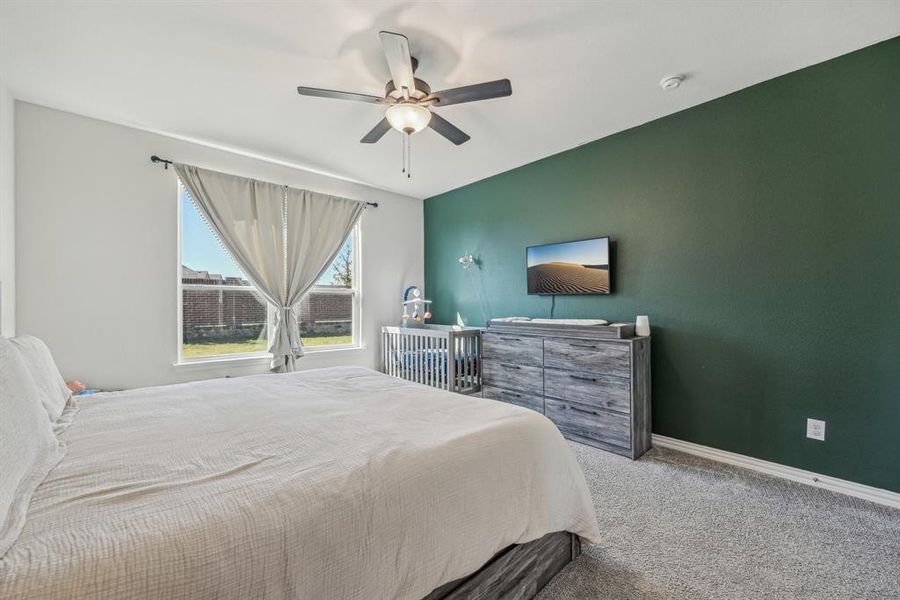 Bedroom with ceiling fan and light carpet