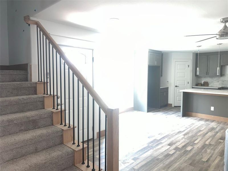 Stairway featuring wood-type flooring and ceiling fan