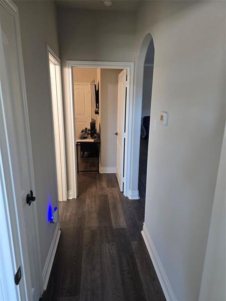 Hallway with dark hardwood / wood-style floors