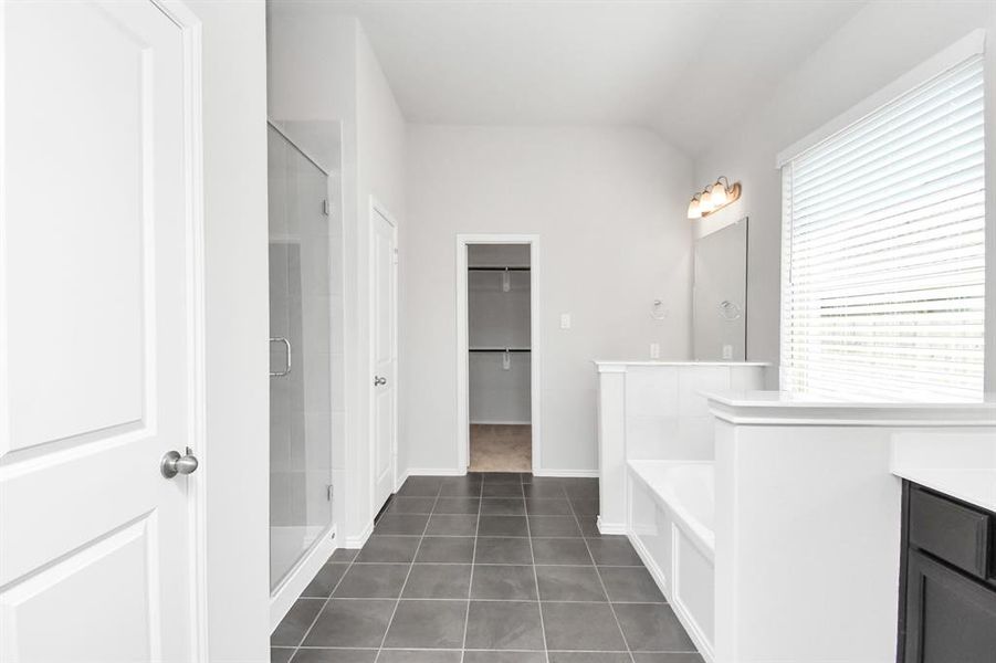 Clean & bright, the primary bathroom is vast with plenty of room during the early morning rush