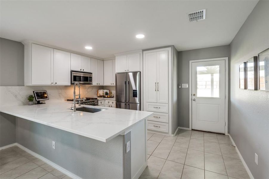 All of the cabinets were custom built to maximize the space in the kitchen. The new quartz countertops were extended to create a place for bar stools for additional seating. The pantry has deep drawers that hold A LOT!