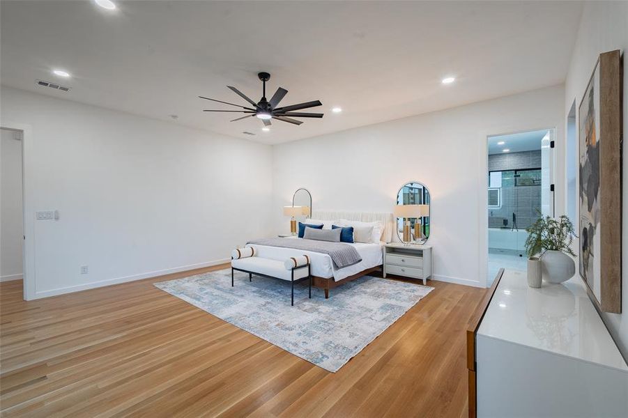 Bedroom with light hardwood / wood-style floors, ensuite bathroom, and ceiling fan