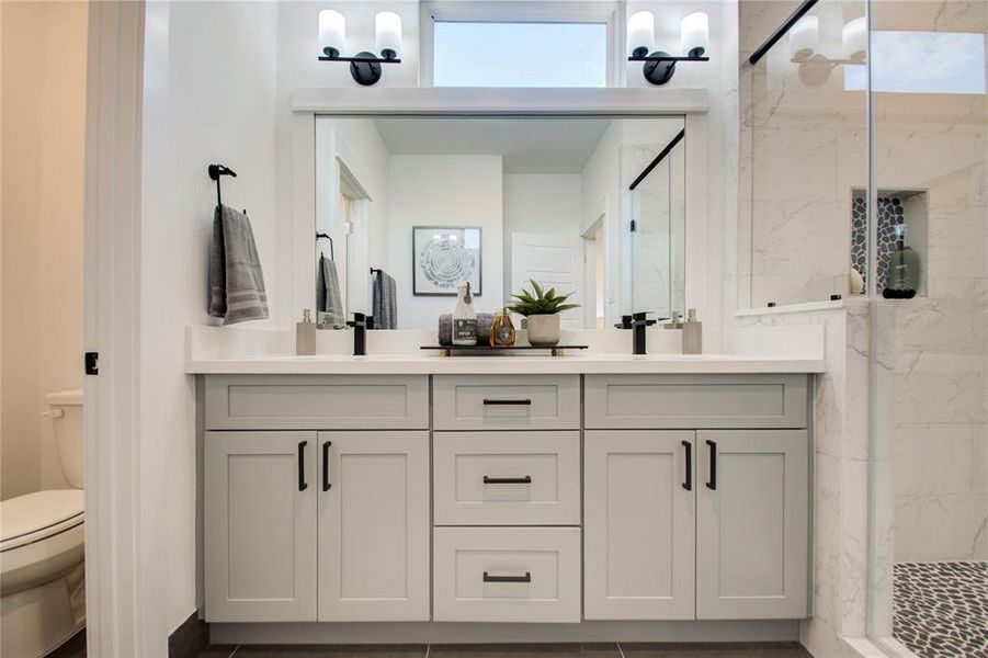 Gorgeous primary bathroom with quartz double sink vanity. Photos from another community by the same builder, FINISHES & FLOOR PLAN WILL VARY!