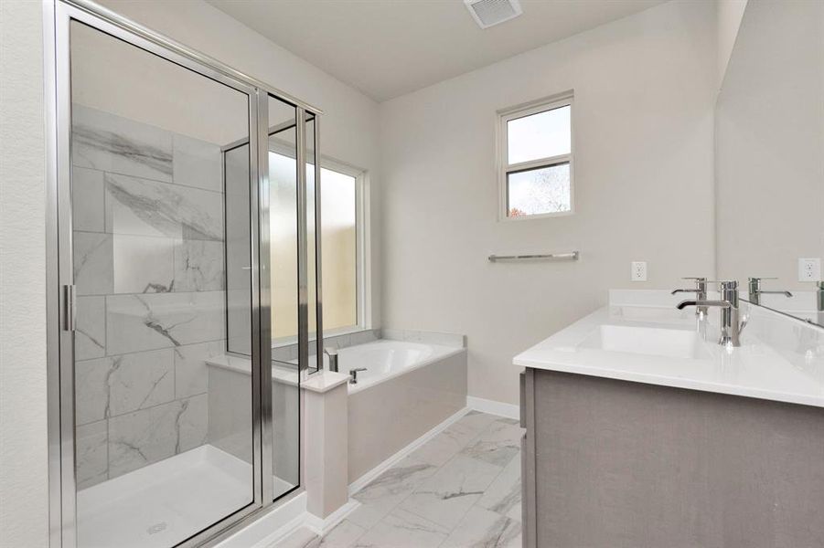 The primary en-suite has a soaking tub to give you that spa experience. The large privacy window allow lots of nature light in the space. Sample photo of completed home with similar floor plan. As-built interior colors and selections may vary.