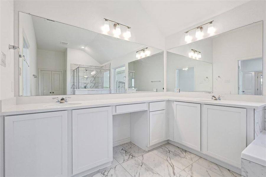 Bathroom featuring lofted ceiling, vanity, and a shower with door