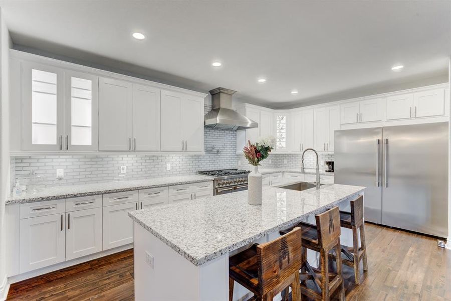 This is a sleek kitchen with current finishes and fixtures like granite countertops, stainless steel appliances, and a subway tile backsplash.