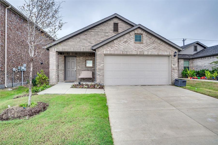 View of front of property with a front yard and a garage