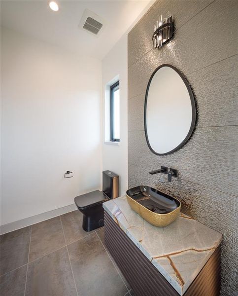 Third floor half bath with elegant built-in vanity, floating tub, framed mirror, wall sconce and exquisite porcelain backsplas