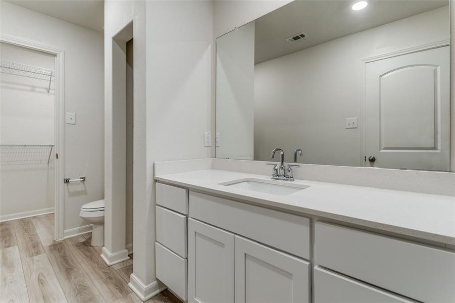 Bathroom with hardwood / wood-style flooring, toilet, and vanity