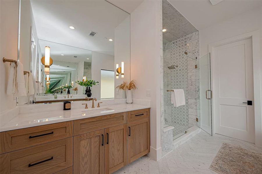 Floor to ceiling polished marble walls in the shower. Fixed & hand held high-end shower fixtures