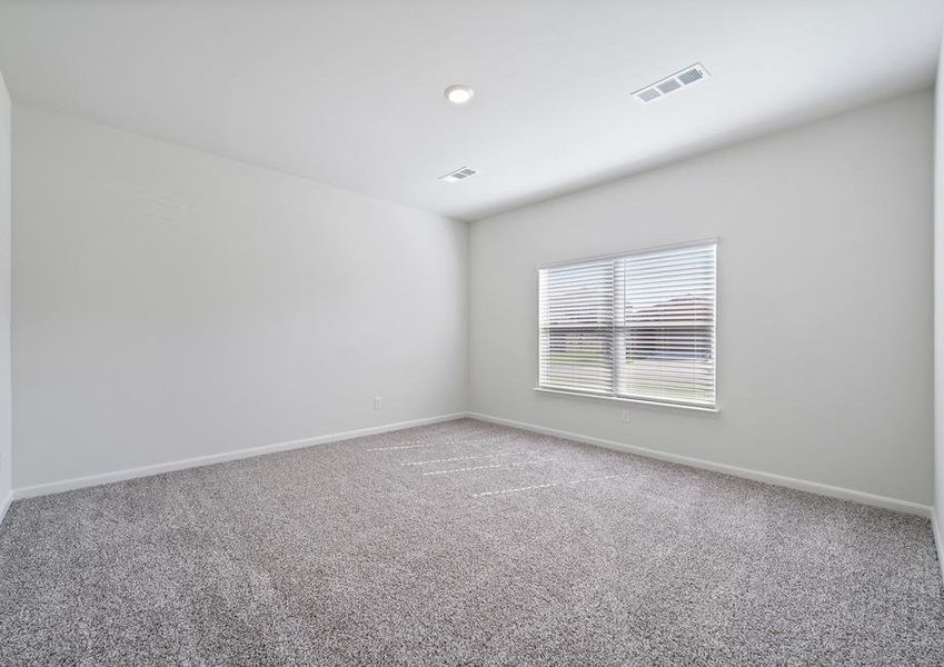 The master bedroom of the Cypress is large with a view of the back yard.