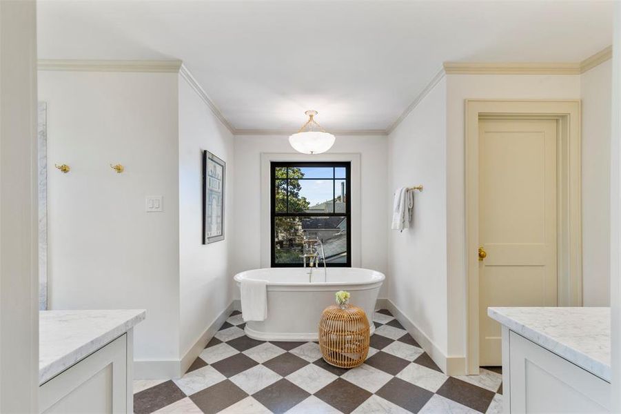 Bathroom with tile floors, crown molding, vanity, and a tub