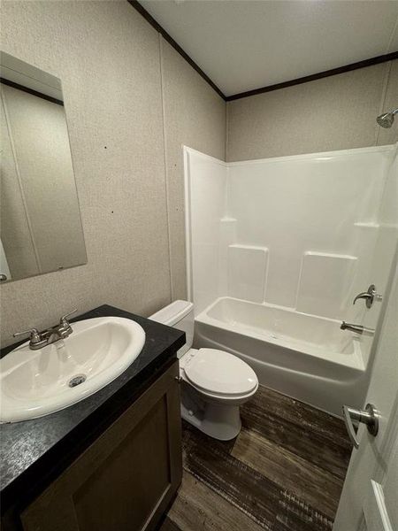 Full bathroom with shower / washtub combination, vanity, toilet, and hardwood / wood-style floors