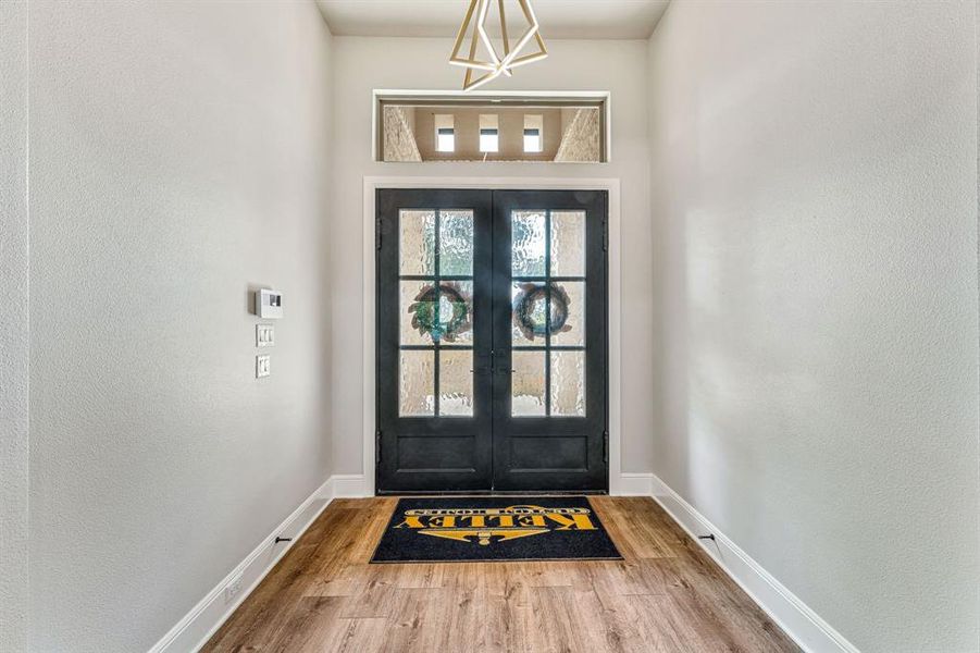 Doorway with hardwood / wood-style flooring and french doors