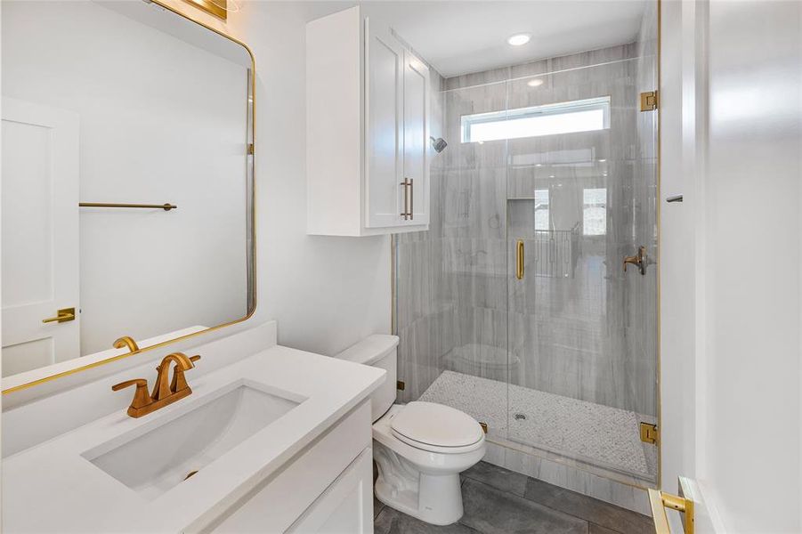 Bathroom with vanity, tile patterned flooring, toilet, and an enclosed shower