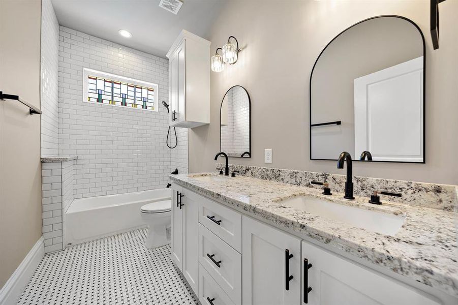 Hall bath on the second floor. Tub for bath time for the kiddos. Double sinks! Custom built cabinets and granite counters