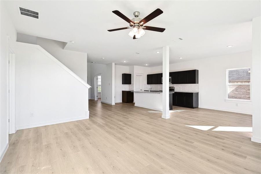 Unfurnished living room featuring ceiling fan and hardwood / wood-style flooring