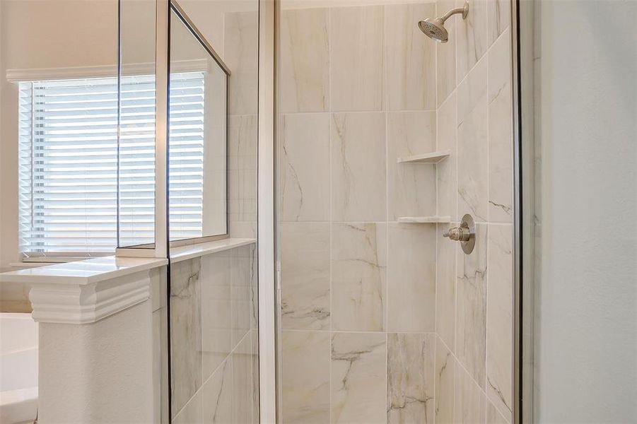 Bathroom featuring an enclosed shower and plenty of natural light