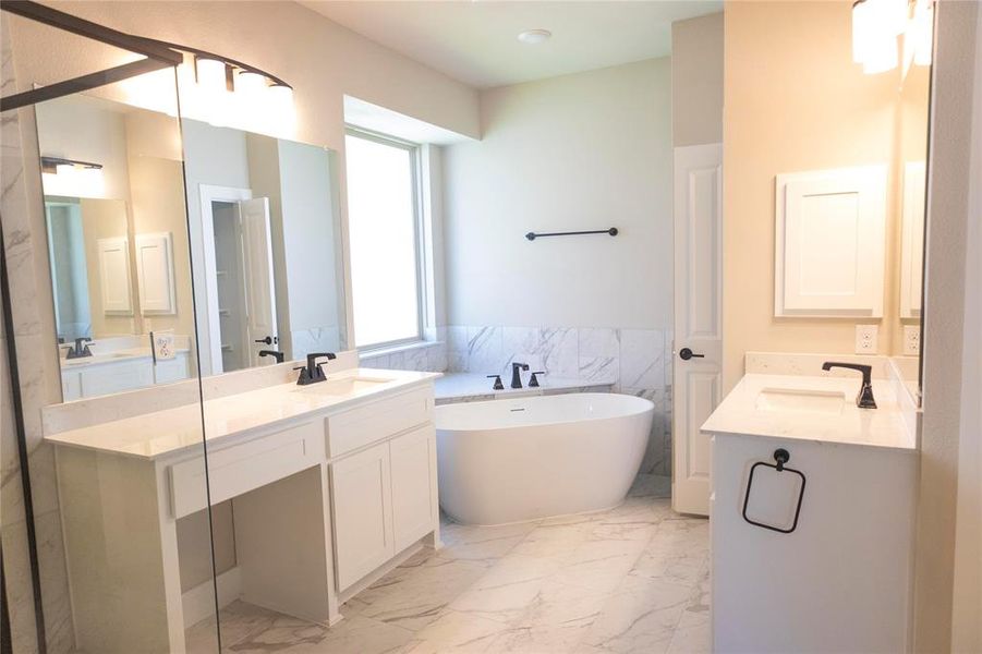 Bathroom featuring tile patterned flooring, tile walls, double vanity, and a bath