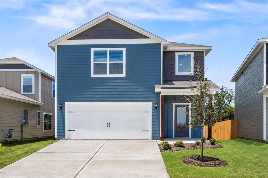 View of front facade featuring a garage and a front yard